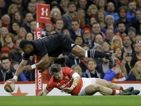 New Zealand's Waisake Naholo, goes over the top of Wales's Steff Evans to score a try, during the rugby union international between Wales and New Zealand in Cardiff, Wales, Saturday, Nov. 25, 2017. (AP Photo/Alastair Grant)