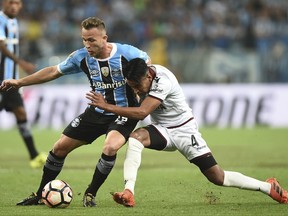 Jose Luis Gomez, right, of Argentina's Lanus fights for a ball with Arthur of Brazil's Gremio, during a first leg Copa Libertadores final soccer match in Porto Alegre, Brazil, Wednesday, Nov. 22, 2017. (AP Photo/Wesley Santos)