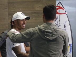 Mercedes driver Lewis Hamilton, of Britain, left, talks with Brazilian surfer Gabriel Medina, ahead of Sunday's Formula One Brazilian Grand Prix, at the Interlagos racetrack, in Sao Paulo, Brazil, Thursday, Nov. 9, 2017. (AP Photo/Andre Penner)