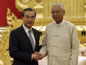 Myanmar's President Htin Kyaw, right, shakes with Chinese Foreign Minister Wang Yi after their meeting at the President House in Naypyitaw, Myanmar, Sunday, Nov. 19, 2017. (AP Photo/Aung Shine Oo)