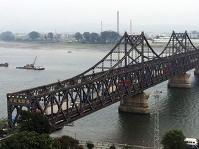 FILE - In this Sept. 4, 2017, file photo, trucks cross the friendship bridge connecting China and North Korea in the Chinese border town of Dandong, opposite side of the North Korean town of Sinuiju. For Chinese traders, new United Nations sanctions on North Korea are a disaster. Business in the Chinese border city of Dandong has all but dried up as Chinese traders are unable to collect payment from impoverished North Korean state companies for goods such as toothpaste, instant noodles and other household items. Large-scale trade involving North Korean iron ore and coal has been banned entirely, dealing a big blow to Dandong's port, whose operator defaulted on a $150 million corporate bond. (AP Photo/Helene Franchineau, File)