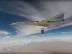 This photo made from the footage taken from Russian Defense Ministry official website Wednesday, Nov. 1, 2017 shows a Russian Tu-22MZ bomber hitting positions of the militants outside the town of Al Bukamal on the border with Iraq in the eastern Deir el-Zour province, the epicenter of heavy fighting with the retreating IS militants. Russia's military says six of its long-range bombers have taken off from air bases in Russia to strike targets on the border between Syria and Iraq. (Russian Defense Ministry Press Service via AP)