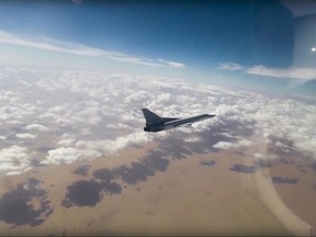 This photo made from the footage taken from Russian Defense Ministry official website Wednesday, Nov. 1, 2017 shows a Russian Tu-22MZ bomber hitting positions of the militants outside the town of Al Bukamal on the border with Iraq in the eastern Deir el-Zour province, the epicenter of heavy fighting with the retreating IS militants. Russia's military says six of its long-range bombers have taken off from air bases in Russia to strike targets on the border between Syria and Iraq. (Russian Defense Ministry Press Service via AP)