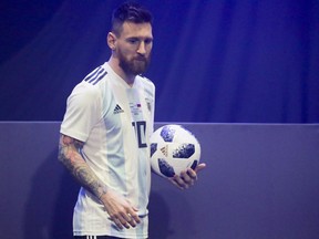 Argentinian national soccer team striker Lionel Messi poses with the official match ball for the 2018 FIFA World Cup Russia, named Telstar 18, during the unveiling ceremony in Moscow, Russia, Thursday, Nov. 9, 2017.  The Telstar 18 has a retro black-and-white design harking back to the original Adidas Telstar ball used for the 1970 World Cup, and Adidas says that in terms of structure, it's an evolution of the ball used for the last World Cup in 2014. (Oleg Shalmer)