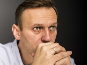 FILE - In this file photo taken on Sunday, Oct. 22, 2017, Russian opposition leader Alexei Navalny sits at his office after being released from a jail in Moscow, Russia. A Moscow court has refused to consider Russian opposition leader Alexei Navalny's suit against President Vladimir Putin over authorities' repeated refusals to sanction his supporters' rallies. (Evgeny Feldman/Navalny Campaign via AP, File)