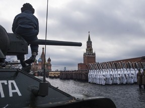 A volunteer sits atop of a legendary Soviet era T-34 tank during a rehearsal of the historical parade in Red Square, in Moscow, Russia, Sunday, Nov. 5, 2017. The parade marked the 76th anniversary of a World War II historic parade in Red Square and honored the participants in the Nov. 7, 1941 parade who headed directly to the front lines to defend Moscow from the Nazi forces. (AP Photo/Alexander Zemlianichenko)