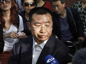 FILE - In this May 2, 2012, file photo, human rights activist Jiang Tianyong speaks to journalists outside a hospital after his failed attempt to see blind Chinese activist Chen Guangcheng who is believed to be seeking treatment in Beijing, China. A court in central China has sentenced Jiang to two years in prison Tuesday, Nov. 21, 2017, on the vague charge of inciting subversion of state power, the latest verdict to be handed down in a sweeping crackdown on activism. (AP Photo/Ng Han Guan, File)