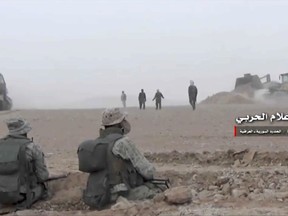 This frame grab from video provided Wednesday, Nov 8, 2017 by the government-controlled Syrian Central Military Media, shows Syrian pro-government troops taking up positions during fighting with insurgents on the Iraq-Syria border. The Britain-based Syrian Observatory for Human Rights, said that Islamic State militants have withdrawn from their last stronghold following a government offensive and that government forces and allied troops, including Iraqi fighters are combing Boukamal, a strategic town on the border with Iraq, Thursday. (Syrian Central Military Media, via AP)