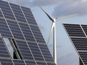 FILE - In this Nov. 30, 2011 file photo photovoltaic modules and a windmill are pictured in the village of Feldheim near Berlin, Germany. The UN Climate Change Conference 2017 will take place under Presidency of the Government of Fiji in Bonn,  Germany and starts on Monday, Nov. 6, 2017. (AP Photo/Michael Sohn, File)