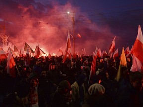 Demonstrators burn flares and wave Polish flags during the annual march to commemorate Poland's National Independence Day in Warsaw, Poland, Saturday, Nov. 11, 2017. Thousands of nationalists marched in Warsaw on Poland's Independence Day holiday, taking part in an event that was organized by far-right groups. (AP Photo/Czarek Sokolowski)