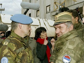 FILE - In this April 9, 1994 file photo, former Bosnian Serb commander Ratko Mladic, right, leaves the UN headquarters at Sarajevo airport after talks with the UN General, Sir Michael Rose and Bosnian Commander Rasim Delic. Ratko Mladic will learn his fate on Nov. 22, 2017, when U.N. judges deliver verdicts in his genocide and war crimes trial. (AP Photo/Enric Marti, File)