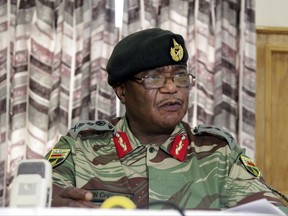 FILE -- In this Monday, Nov. 13, 2017, file photo, Zimbabwe's Army Commander, Constantino Chiwenga addresses a press conference in Harare. Armored personnel carriers were seen outside the capital a day after the army commander Chiwenga threatened to "step in" to calm political tensions over the president's firing of his deputy. (AP Photo/Tsvangirayi Mukwazhi, File)
