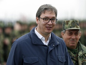 Serbia's President Aleksandar Vucic, left, reviews the honor guard with Chief-of-staff of the Serbian Armed Forces Ljubisa Dikovic during a bilateral Serbian and U.S. airborne exercise at Lisicji jarak airport, some 15 kilometers (10 miles) north of Belgrade, Serbia, Friday, Nov. 17, 2017. American and Serbian paratroopers have held joint exercises in Serbia which is watched with unease in Russia that is trying to increase its influence in the Balkans. (AP Photo/Darko Vojinovic)