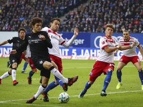 Stuttgart's Benjamin Pavard, left, and Hamburg's Albin Ekdal , center and Jann-Fiete Arp, second right, challenge for the ball  during the German Bundesliga soccer match between Hamburger SV and VfB Stuttgart in Hamburg, Germany, Saturday, Nov. 4, 2017. (Christian Charisius/dpa via AP)