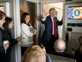 President Donald Trump, accompanied by White House press secretary Sarah Huckabee Sanders, third from left, talks to reporters aboard Air Force One, Friday, Nov. 3, 2017, while traveling to Joint Base Pearl Harbor Hickam, in Hawaii. Trump begins a five country trip through Asia traveling to Japan, South Korea, China, Vietnam and the Philippians. (AP Photo/Andrew Harnik)
