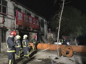In this photo provided by China's Xinhua News Agency, firefighters work at the site of a fire in Daxing district of Beijing, capital of China, Sunday, Nov. 19, 2017.  The official Chinese news agency says a fire at a building advertising low-cost rental apartments in a southern Beijing suburb has killed more than a dozen of people. (Xinhua/Luo Xiaoguang)