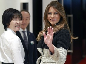 U.S. first lady Melania Trump waves to photographers as she and her Japanese counterpart Akie Abe, left, visit Mikimoto Ginza Main Store, Japan's pearl jewelry maker, at Ginza shopping district in Tokyo Sunday, Nov. 5, 2017. (AP Photo/Shizuo Kambayashi)
