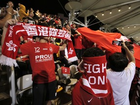 Hong Kong soccer fans cover their faces and boo the Chinese national anthem before the friendly match against Bahrain football team in Hong Kong, Thursday, Nov. 9, 2017. Hong Kong soccer fans again booed China's national anthem at the Thursday night match in the Chinese-controlled city, defying Beijing authorities days after communist leaders moved to tighten up penalties for disrespecting the song. (AP Photo/Kin Cheung)