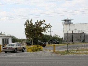 FILE - In this Sept. 18, 2012 file photo, Mexican army soldiers guard an entrance to the state prison in Piedras Negras, Mexico. Officially it was a prison, but inside it hid another reality: a center of operations where the Zetas cartel modified vehicles and manufactured uniforms, locked up kidnap victims and dissolved bodies in acid, according to a College of Mexico report released Tuesday, Nov. 21, 2017, based on witness statements, documents and public data. (AP Photo/Adriana Alvarado, File)