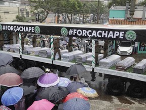 FILE - In this Dec. 3, 2016 file photo, coffins with the remains of Chapecoense soccer team members who died in a plane crash, are transported to the team's stadium for a memorial in Chapeco, Brazil. The soccer club is opening the gates of its stadium on midnight Tuesday, Nov. 28, 2017, so fans can pray and pay their respects to victims of the LaMia flight that crashed near Medellin a year ago, killing 71 people including 19 Chapecoense players. (AP Photo/Andre Penner, File)