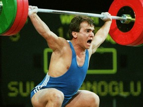 FILE- In this July 22, 1996 file photo, Naim Suleymanoglu, of Turkey, lifts 147.5kg, at the Summer Olympics in Atlanta. Turkey's official news agency said Saturday, Nov. 18, 2017, Suleymanoglu, the Turkish weightlifter who was known as "Pocket Hercules" and who won three straight Olympic gold medals for Turkey between 1988 and 1996, has died. Suleymanoglu was considered one of the sport's greatest athletes and earned his nickname for his strength and diminutive size. He was 50. (AP Photo/Michael Probst, File)