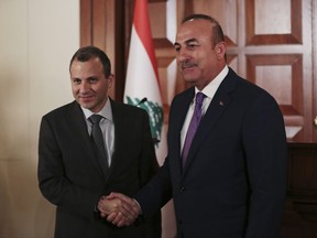 Lebanon's Foreign Minister Gebran Bassil, left, shakes hands with his Turkish counterpart Mevlut Cavusoglu, right, after their joint news conference following their meeting in Ankara, Turkey, Thursday, Nov. 16, 2017. (AP Photo/Burhan Ozbilici)
