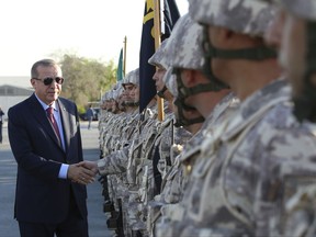Turkey's President Recep Tayyip Erdogan, left, shakes hands with Turkish Armed Forces's soldiers during his visit at the Qatari-Turkish Armed Forces Land Command Base in Doha, Qatar, Wednesday, Nov. 15, 2017. Erdogan, who also visited Kuwait on Tuesday, met with Qatar's Emir on Wednesday and the five-months dispute between Qatar and its Gulf neighbours, regional affairs and bilateral relations were discussed during the visits. (Yasin Bilbul/Pool via AP)