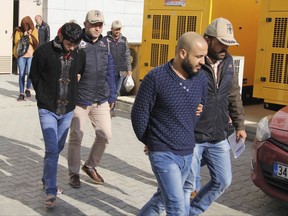 Turkish police officers escort people suspected of being Islamic group militants, outside a court in the Black sea region city of Samsun, Turkey, Thursday, Nov. 9, 2017. Police on Thursday detained at least 111 suspected Islamic State group militants in a sweep in the capital, Ankara, Police on Thursday detained at least 111 suspected Islamic State group militants in raids in the capital, Ankara, Turkey's state-run news agency reported.Authorities had detention warrants for a total of 245 IS suspects, Anadolu Agency said, suggesting that operations for the other alleged militants were continuing. (Muhammer Ay/IHA Photos via AP)