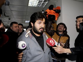 FILE - In this Tuesday, Dec. 17, 2013 file photo, Turkish-Iranian businessman Reza Zarrab, who is charged currently in the U.S. for evading sanctions on Iran, is surrounded by the media members as he arrives at a courthouse in Istanbul,in a separate case against him. Turkey's Deputy Prime Minister Bekir Bozdag on Monday, Nov. 20, 2017 depicted an upcoming trial in the United States against Zarrab, the main defendant, as a "conspiracy" against Turkey and also described him AS a "hostage" who he claimed was being forced to testify against Turkey's government. Trial begins in New York on Nov. 27.  (Depo Photos via AP, File)