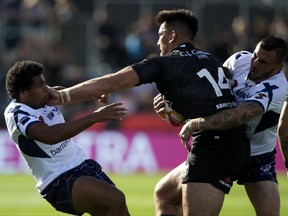 New Zealand's Nelson Asofa-Solomona fends off Scotland's Oscar Thomas, left, during their Rugby League World Cup game in Christchurch, New Zealand, Saturday, Nov. 4, 2017. (AP Photo/Mark Baker)