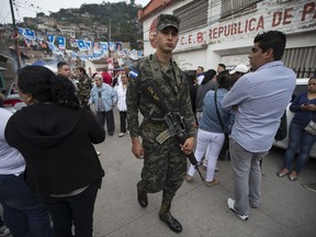 A soldier patrols outside a polling station during the general elections in Tegucigalpa, Honduras, Sunday, Nov. 26, 2017. Honduran President Juan Orlando Hernandez, a conservative U.S. ally, tries to win a second term on Sunday despite opposition claims that his re-election is an unconstitutional power grab. (AP Photo/Moises Castillo)
