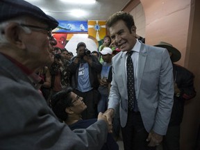 Opposition Alliance presidential candidate Salvador Nasralla, right, shakes hands with a supporter during a meeting with party leaders, in Tegucigalpa, Honduras, Friday, Nov. 24, 2017. General elections will be held nationwide on Sunday. (AP Photo/Moises Castillo)