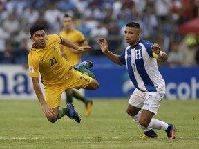 Australia's Massimo Luongo, left, is taken down by Honduras' Emilio Izaguirre during the first leg of a soccer World Cup qualifier play-off at the Olympic Stadium in San Pedro Sula, Honduras, Friday, Nov. 10, 2017. (AP Photo/Moises Castillo)