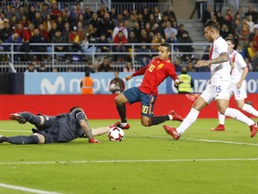 Costa Rica goalkeeper Danny Carvajal, left, makes a save as Spain's Thiago Alcantara, center, tries to score during the international friendly soccer match between Spain and Costa Rica in Malaga, Spain, Saturday, Nov. 11, 2017. (AP Photo/Miguel Morenatti)