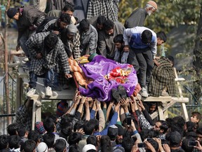 Kashmiri villagers carry the body of local rebel Waseem Ahmad, during his funeral procession in Drubgam, 48 kilometers (30 miles) south of Srinagar, Indian controlled Kashmir, Tuesday, Nov. 7, 2017. Three militants and an Indian army soldier were killed in a gun-battle in disputed Kashmir, officials said Tuesday. ( AP Photo/Mukhtar Khan)