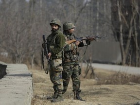 Indian army soldiers guard during a gunbattle at Pakharpore village, south of Srinagar, Indian controlled Kashmir, Thursday, Nov. 30, 2017. At least five rebels were killed and three civilians and a soldier injured on Thursday in armed confrontations and anti-India protests in the disputed region, officials said. (AP Photo/Mukhtar Khan)