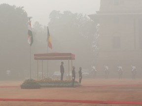 Belgium's King Philippe inspects a military guard of honour, surrounded by smog, at the Indian Presidential palace in New Delhi, India, Tuesday, Nov. 7, 2017.