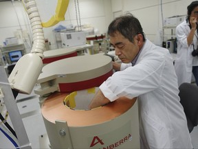 In this Oct. 11, 2017 photo, a lab technician at the Fukushima Agricultural Technology Center, which monitors safety in farm and fisheries products from across the prefecture, places a sample inside a radiation counter to measure cesium levels, in Koriyama city, Fukushima prefecture. (AP Photo/Mari Yamaguchi)