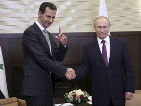 In this Monday, Nov. 20, 2017, photo, Russian President Vladimir Putin, right, shakes hands with Syrian President Bashar Assad in the Bocharov Ruchei residence in the Black Sea resort of Sochi, Russia. Putin has met with Assad ahead of a summit between Russia, Turkey and Iran and a new round of Syria peace talks in Geneva, Russian and Syrian state media reported Tuesday. (Mikhail Klimentyev, Kremlin Pool Photo via AP)