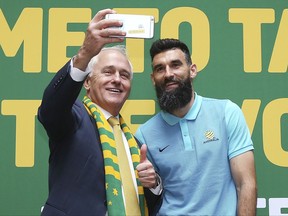 Australian Prime Minister Malcolm Turnbull, left, takes a selfie photo with Australian soccer team captain Mile Jedinak during a reception following their qualification to the 2018 soccer World Cup in Sydney, Australia, Thursday, Nov. 16, 2017. Australia's 3-1 victory over Honduras secured the next-to-last spot in the World Cup in Russia. (AP Photo/Rick Rycroft)