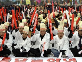 FILE - In this Nov. 25, 2008, file photo, South Korean farmers shout slogans during an anti-FTA rally near the National Assembly in Seoul, South Korea. The Korean read " Oppose the FTA between the South Korean and U.S." President Donald Trump visits South Korea on Tuesday, Nov. 7, 2017, on the second leg of his first official Asian tour. While Trump will be looking to use his trip to strengthen Washington's alliance with Seoul and reaffirm their joint push to maximize pressure on North Korea over its nuclear program, he will also be faced with several thorny issues weighing on the relationship. (AP Photo/ Lee Jin-man, File)