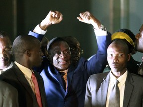 Zimbabwe's incoming leader Emmerson Mnangagwa, centre, gestures as he greets the crowd upon arrival at the Zanu PF  Headquarters in Harare, Wednesday, Nov, 22, 2017.  Mnangagwa has emerged from hiding and returned home ahead of his swearing-in Friday. Crowds have gathered at the ruling party's headquarters for his first public remarks. Mnangagwa will replace Robert Mugabe, who resigned after 37 years in power when the military and ruling party turned on him for firing Mnangagwa and positioning his wife to take power. (AP Photo/Tsvangirayi Mukwazhi)
