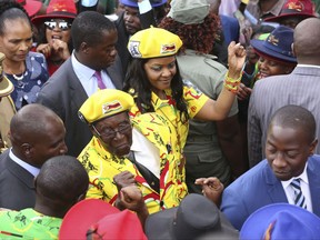 Zimbabwe President Robert Mugabe, center left, and his wife Grace greet supporters upon arrival for a solidarity rally in Harare, Wednesday, Nov. 8, 2017. Zimbabwe's president said Wednesday he fired his deputy and longtime ally for scheming to take power, including by consulting witch doctors. Now Mugabe's wife appears poised for the role. (AP Photo)