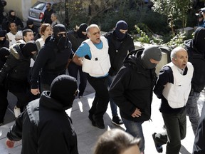 Turks escorted by anti-terror police arrive at a court in Athens, Wednesday, Nov. 29, 2017. Greek counter-terrorism police detained nine Turks in Athens on Tuesday in an investigation into Turkish leftist militant groups, ahead of a scheduled visit next month by Turkey's President Recep Tayyip Erdogan. (AP Photo/Thanassis Stavrakis)