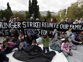 Stranded migrants and refugees demonstrate during a rally in Athens, Wednesday, Nov. 1, 2017. A few dozens people, among them young children, protested against delays in reuniting with their relatives in Germany as some of them will start hunger strike in front of the Greek Parliament. (AP Photo/Thanassis Stavrakis)