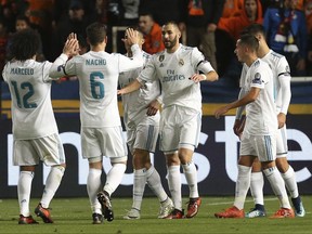 Real Madrid's Karim Benzema, center, celebrates after scoring the fourth goal of his team during the Champions League Group H soccer match between APOEL Nicosia and Real Madrid at GSP stadium, in Nicosia, on Tuesday, Nov. 21, 2017. (AP Photo/Petros Karadjias)