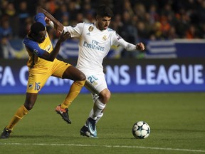 Real Madrid's Marco Asensio, right, and APOEL's Vinicius challenge for the ball during the Champions League Group H soccer match between APOEL Nicosia and Real Madrid at GSP stadium, in Nicosia, on Tuesday, Nov. 21, 2017. (AP Photo/Petros Karadjias)