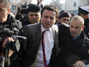 Kosovo top opposition lawmaker Albin Kurti, center, is arrested by Kosovo police officers on his way to a parliamentary session on Friday, Nov. 24, 2017, in Kosovo capital Pristina. Kosovo police arrested top opposition leader Albin Kurti and two other lawmakers accused of disrupting the works of the previous parliament with tear gas and violent acts. (AP Photo)
