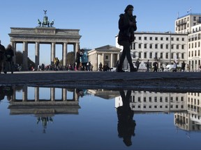 The Brandenburg Gate reflected by a puddle on Pariser Platz  Square  in Berlin, Germany, Tuesday, Nov. 7, 2017.  (Ralf Hirschberger/dpa via AP)