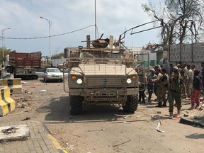 Yemeni men and security forces inspect the site of a suicide bombing in the southern port city of Aden, on November 5, 2017.
